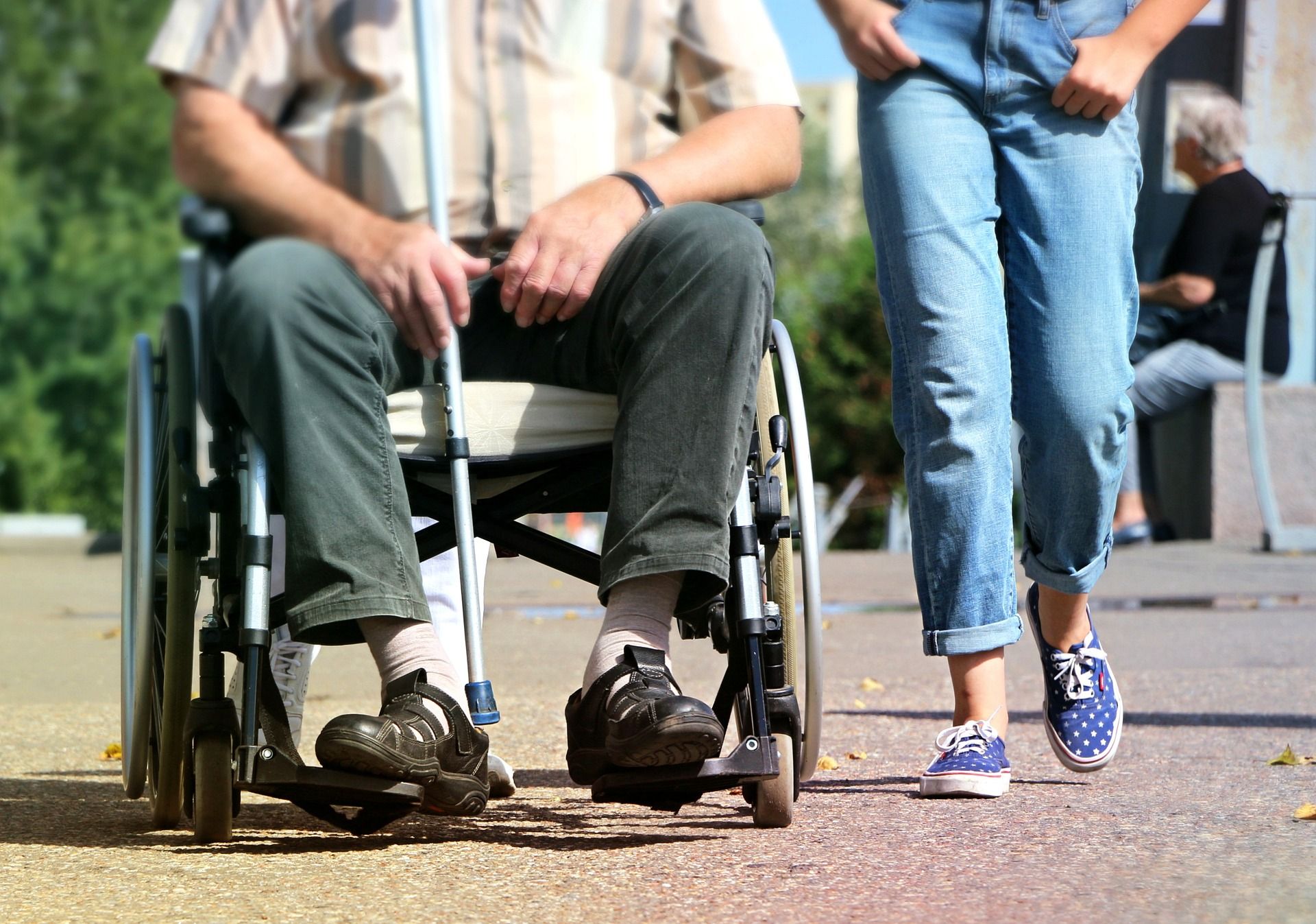 Person im Rollstuhl mit Gehst&uuml;tze